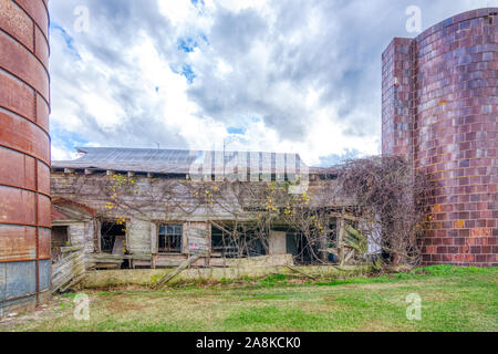 Abbandonato fienile con silo sotto nuvole temporalesche nella contea di Alamance Carolina del Nord Foto Stock