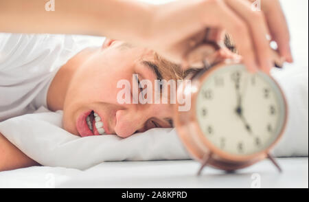 Giovane uomo è mattina sconvolto grimace risveglio sveglia. Foto Stock