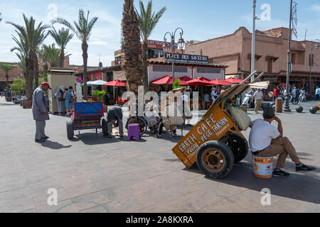 Uomo e persone con carriole a Marrakech. Il Marocco, in ottobre 2019 Foto Stock