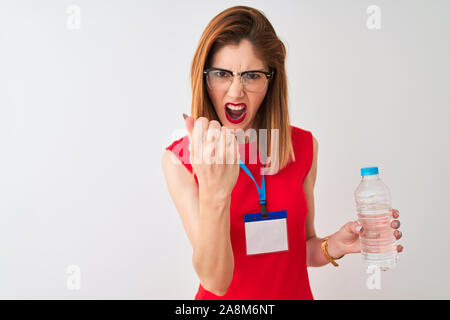 Redhead imprenditrice indossando id card acqua potabile isolato su sfondo bianco infastiditi e frustrato grida con rabbia, crazy e urla con Foto Stock