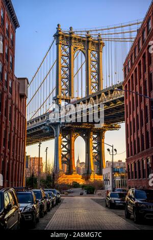 Vista dalla strada principale a Manhattan Bridge e Empire State Building, con sole di mattina, Dumbo, Brooklyn, New York, Stati Uniti d'America Foto Stock