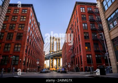 Vista dalla strada principale a Manhattan Bridge e Empire State Building, con sole di mattina, Dumbo, Brooklyn, New York, Stati Uniti d'America Foto Stock