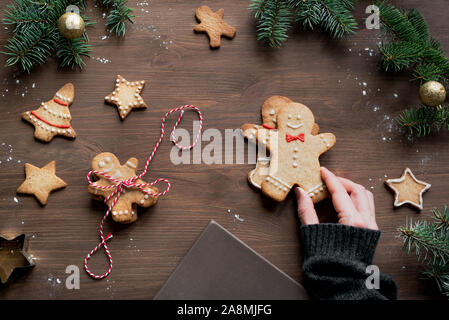 Natale Gingerbread cookie su sfondo di legno, vista dall'alto, copia dello spazio. In casa di festa tradizionale gingerbread man e stelle per il dono, laici piana. Foto Stock