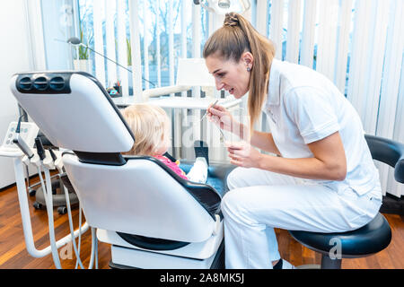 Dentista di trattare un bambino nel suo ufficio Foto Stock