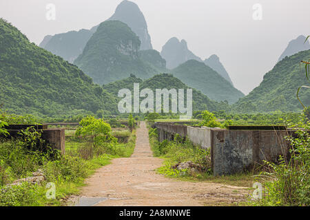 Piccola strada attraverso il terreno coltivato nelle colline carsiche nelle vicinanze di Yangshuo vicino a Guilin Foto Stock