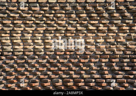 Un frammento della muratura originale di mattoni bruciati costruito da Roma antica. Sfondo. Pattern. Ocra, marrone. Foto Stock