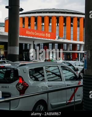 Madrid, Spagna - Novembre 9, 2019: fila di taxi bianco di fronte alla stazione ferroviaria di Atocha di Madrid in Spagna in attesa per i passeggeri Foto Stock