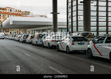 Madrid, Spagna - Novembre 9, 2019: fila di taxi bianco di fronte alla stazione ferroviaria di Atocha di Madrid in Spagna in attesa per i passeggeri Foto Stock