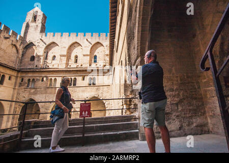 Avignone, PROVENZA / Francia - 27 Settembre 2018: grey-haired pensionati per cuffie con audio guide visita gli interni del Palazzo Papale Foto Stock