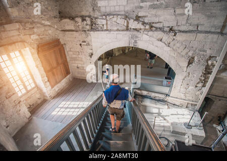 Avignone, PROVENZA / Francia - 27 Settembre 2018: grey-haired pensionati per cuffie con audio guide visita gli interni del Palazzo Papale Foto Stock