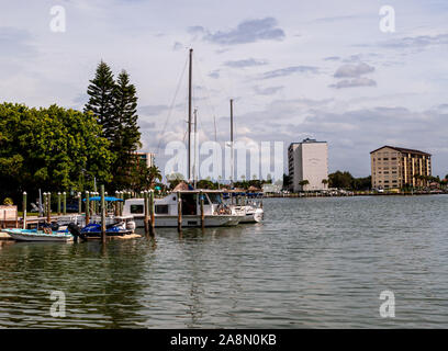 Barche ormeggiate in una baia con edifici di appartamenti sull'altro lato dell'acqua su una caduta giorno, Clearwater Beach, Florida, Stati Uniti d'America Foto Stock