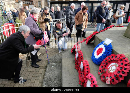 Hereford, Herefordshire, Regno Unito - Domenica 10 Novembre 2019 - i membri del pubblico si riuniscono per visualizzare e leggere i messaggi sul papavero ghirlande collocato presso il memoriale di guerra in Piazza San Pietro subito dopo il servizio del ricordo. Molti dei tributi si riferiscono al livello locale 22 SAS ( Special Air Service ) reggimento. Foto Steven Maggio / Alamy Live News Foto Stock