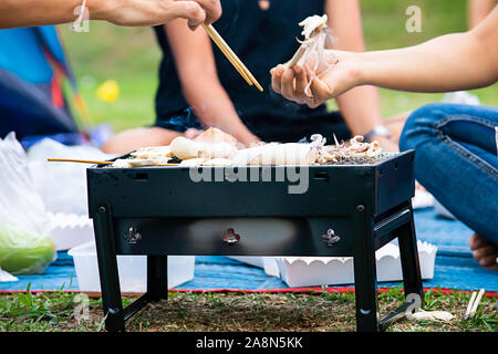 Calamari freschi e funghi sulla griglia in acciaio. Foto Stock