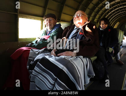 Guerra mondiale due veterani Roy Briggs (sinistra) e George Prichard sul bordo di una guerra mondiale II Dakota, durante una caduta di tre quarti di un milione di papaveri oltre le Bianche Scogliere di Dover in un omaggio ai caduti il giorno dell'armistizio. Foto Stock