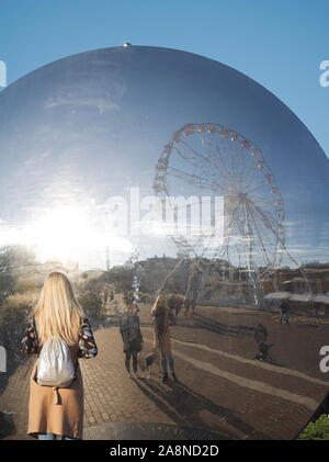 Guardare la gente di Győr Cityscape riflessione in Pulzus moderne sculture pubbliche sulla piazza Dunakapu Foto Stock