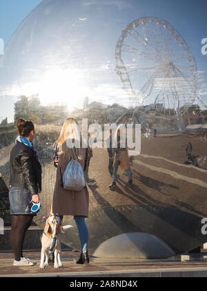 Guardare la gente di Győr Cityscape riflessione in Pulzus moderne sculture pubbliche sulla piazza Dunakapu Foto Stock