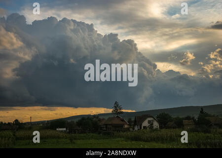 Lo sviluppo di nubi oltre il paesaggio della Transilvania al tramonto Foto Stock