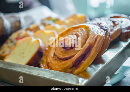 Assortimento di pane appena sfornato dolci per la vendita su un contatore di panetteria francese Foto Stock