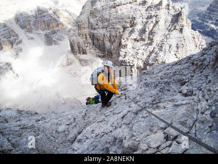 Attraente bruna scalatore femmina su una ripida ed esposta Via Ferrata nelle Dolomiti Foto Stock