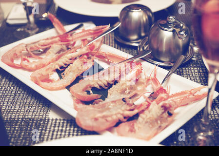Materie scampi piatto sul tavolo ristorante - saporiti frutti di mare, tonica foto Foto Stock