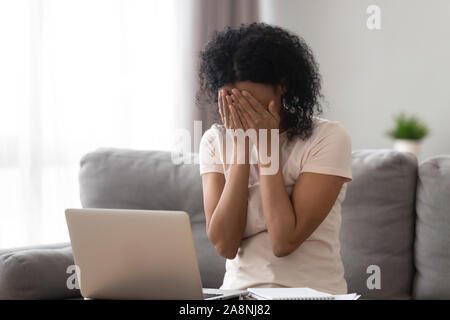 African American donna nascondendo la faccia nelle mani, ricevuto cattive notizie Foto Stock