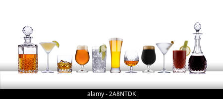 Una linea di bevande aclcoholic dal whisky ai lager, in linea su una barra bianca come la superficie con uno sfondo bianco Foto Stock