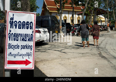 Multi-lingua segno per il parcheggio per le bici, in thai, inglese e birmano, al Wat Phra That Doi kham, o tempio d'oro, vicino a Chiang Mai, Thailandia del Nord Foto Stock