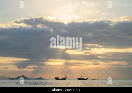 Vista tramonto su Labuan Bajo, Nusa Tenggara orientale, Indonesia, con silhouette di due phinisi barca Foto Stock