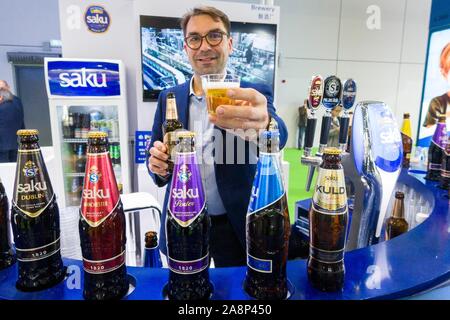 (191110) -- Shanghai, nov. 10, 2019 (Xinhua) -- un membro del personale mostra un bicchiere di birra da Estonia a cibo e prodotti agricoli area espositiva durante la seconda China International Import Expo (CIIE) a Shanghai in Cina orientale, nov. 7, 2019. (Xinhua/Cai Yang) Foto Stock