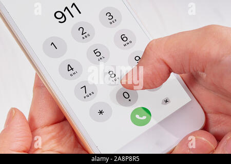 Chiamata di emergenza tenendo le mani un telefono Foto Stock