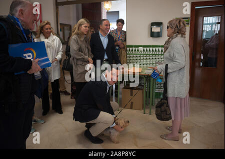 Andalusa di Presidente Regionale e leader di Andalusia Partito Popolare, Juanma Moreno accarezzando un cane ad un seggio elettorale durante le elezioni.La spagnola le elezioni generali sono guidati dal radicale crescente ala destra partito, VOX guidato dal suo principale candidato, Santiago Abascal con un numero elevato di sedi: secondo i più recenti sondaggi. Ciò supporrebbe un duro colpo per i tradizionali partiti di sinistra. Foto Stock