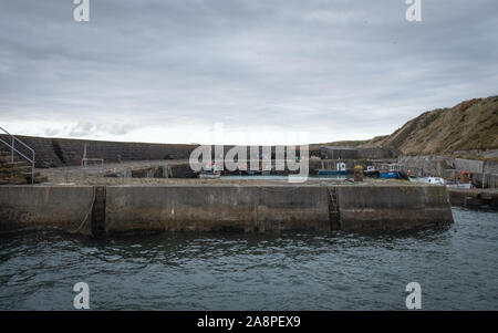 Una vista di Keiss porto di Caithness in Scozia in una fredda giornata autunnale. Foto Stock