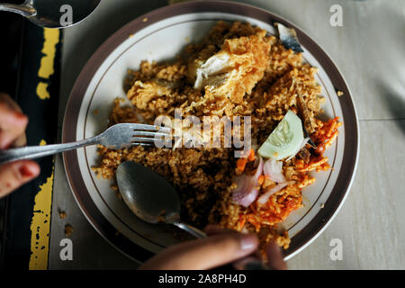 Il cliente di mangiare il Nasi Goreng Ayam, Indonesiana riso fritto a street market alimentare Foto Stock