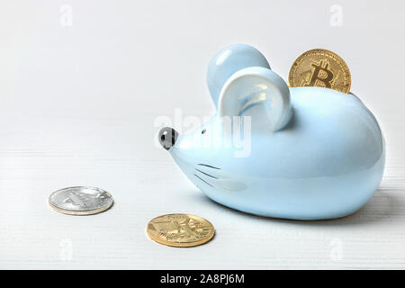 Il blu di topo o di ratto salvadanaio su uno sfondo bianco con bitcoin monete. Concetto per argomenti su valute e finanza, oroscopo e nuovo anno 2020. Foto Stock