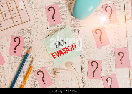 La scrittura della nota che mostra l'evasione fiscale. Il concetto di business per il mancato pagamento o la deliberata mancato pagamento di imposte strumenti di scrittura e scarabocchiati su carta Foto Stock