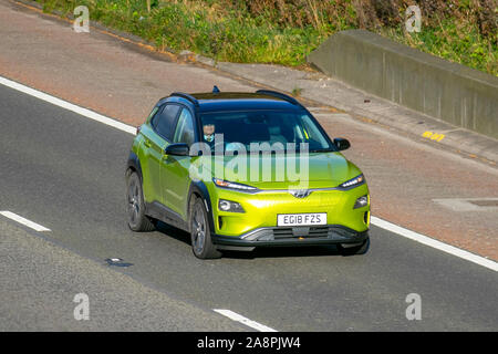 2018 yellow green Hyundai Kona Premium se EV Auto; UK traffico veicolare, trasporto, veicoli moderni, berline, EVS, berlina elettrica premium, berlina elettrica, veicoli elettrici, motore elettrico, EV, proprietario di auto elettriche, direzione sud sull'autostrada 3, corsia M6. Foto Stock