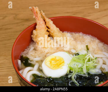 Tempura udon con gamberi fritti, uova sode, alghe verdi, porri, tipica tagliatelle tradizionale cibo giapponese Foto Stock