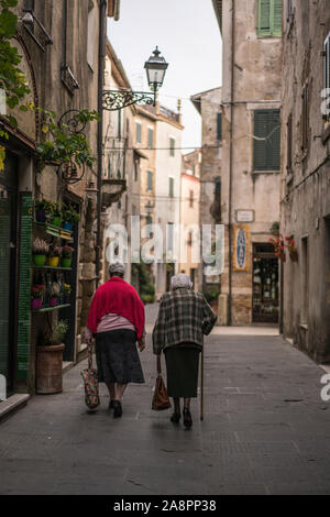 La popolazione locale per la strada del borgo di Pitigliano, Toscana, Italia, Europa. Foto Stock