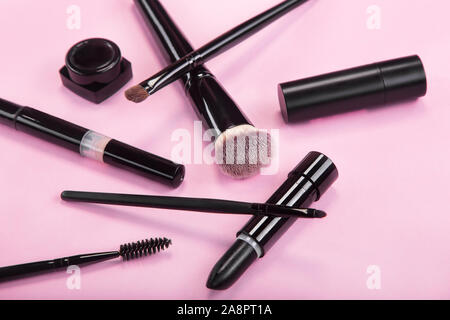 Set di spazzole e prodotti cosmetici su un sfondo rosa. Foto Stock