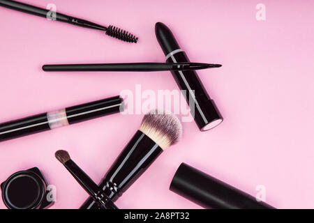 Set di spazzole e prodotti cosmetici su un sfondo rosa. Foto Stock
