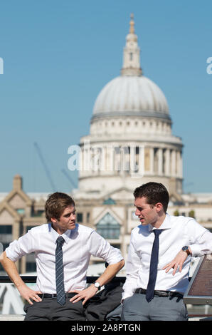 Londra - 28 SETTEMBRE 2011: Coppia di giovani uomini d'affari parlano davanti alla vista dello skyline della Cattedrale di Saint Paul sulla riva sud del Tamigi. Foto Stock