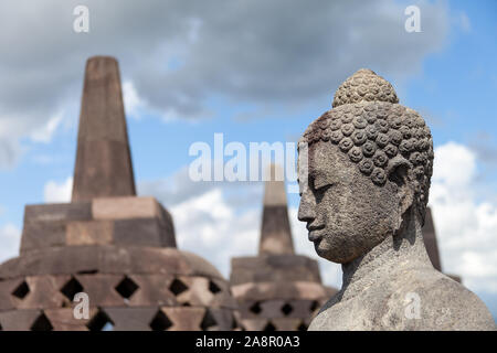 Un Buddah nel suo stupa di Borobodur affacciato sul terreno circostante e a guardare oltre i vulcani. Alcuni di essi sono aperti durante la stagione secca. Uno stun Foto Stock