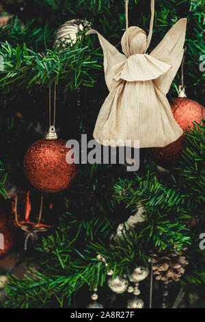 Corn buccia doll su albero di natale. Rosso e argento palle di Natale, baubles. La figura fatta da Corn buccia su albero di natale. Concetto di natale. Primo piano. Foto Stock