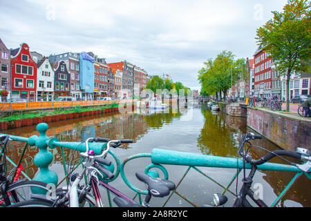 Amsterdam, Nethertlands - 14.10.2019: biciclette su un ponte attraverso i canali di Amsterdam. Case colorate e fiori. L'autunno. Il viaggio. Foto Stock