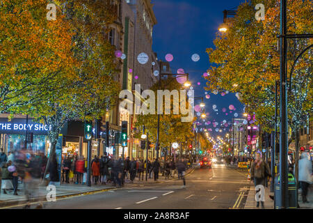 LONDON, Regno Unito - 11 NOVEMBRE 2018: Viste lungo Oxford Street con colorate decorazioni di Natale e le luci. Un sacco di persone può essere visto. Foto Stock