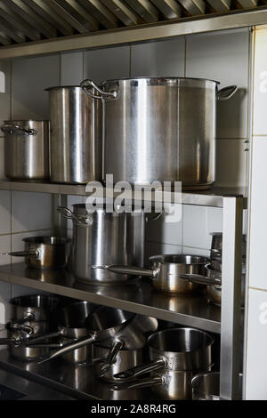 Pentole di metallo sulla cremagliera a cucina nel ristorante Foto Stock