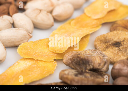 Vista ravvicinata di pistacchi di Bronte, mango essiccato e figure isolate su bianco Foto Stock