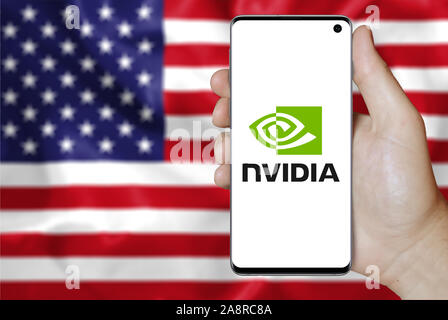 Il logo della società pubblica NVIDIA Corporation visualizzata su uno smartphone. Bandiera degli Stati Uniti sullo sfondo. Credito: PIXDUCE Foto Stock