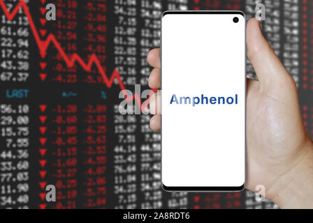 Il logo della società pubblica Amphenol Corp visualizzato su uno smartphone. Stock negativi sullo sfondo del mercato. Credito: PIXDUCE Foto Stock
