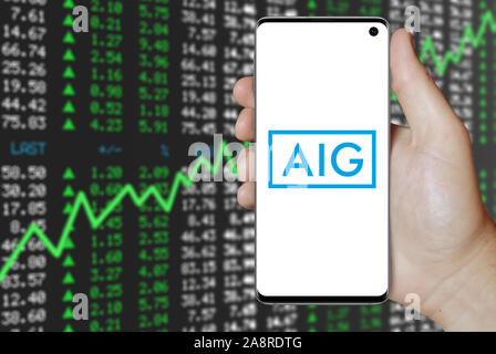 Il logo della società pubblica American International Group visualizzata su uno smartphone. Positivo del mercato azionario sfondo. Credito: PIXDUCE Foto Stock
